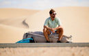 Rider che riposa seduto sulla sua borsa da viaggio Duotone su una strada nel deserto, collezione Boardbag Single Compact 2027
