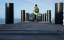 Rider che cammina su un pontile con due borse da viaggio Duotone, collezione Boardbag Single Foil 2027