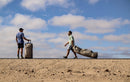 Dos riders arrastrando bolsas de viaje Duotone marfil por un camino de tierra, colección Boardbag Single Surf 2027