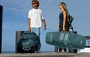 Dois riders num cais com capa individual e saco de viagem Duotone verdes, coleção Boardbag Single Twintip 2027