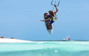 Rider haciendo un aéreo con tabla de surf y la Duotone Click Bar 2027 sobre agua turquesa