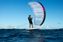Finn Spencer haciendo kitefoil en mar abierto con una cometa Duotone blanca y magenta