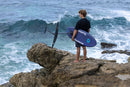 Rider con la Duotone Crush SLS 2027 bajo el brazo mirando las olas desde las rocas