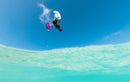 Rider a fazer uma manobra invertida no ar com o Duotone Dice SLS 2025 sobre uma lagoa turquesa