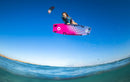 Rider a saltar com uma twintip cor-de-rosa e o kite Duotone Dice SLS 2026 sobre o mar