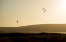 Rider a saltar com o kite Duotone Dice SLS 2026 ao pôr do sol em frente à costa