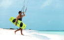 Rider caminando por la playa con una twintip Jaime SLS lima y fijaciones Duotone Entity Ergo 2027