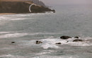 Rider a surfar ondas com o Duotone Evo SLS 2026 Concept Blue numa costa rochosa