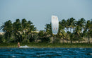 Rider a navegar com o Duotone Evo SLS 2026 numa lagoa tropical com palmeiras