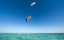 Rider in the air with the Duotone Evo SLS 2027 over a turquoise sea, same model as the Concept Blue