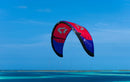 Rider on the blue and red Duotone Evo SLS 2027 over turquoise tropical water, same model as the Concept Blue