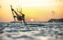 Rider Duotone réalisant une figure avec sa twintip au coucher du soleil
