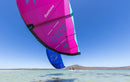 Kites Duotone Juice 2026 rosa e azul a voar sobre uma lagoa