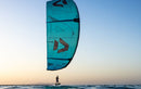 Kite Duotone Juice D/LAB 2026 turchese in volo con un rider di foil al tramonto