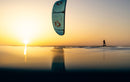 Rider di foil con il kite Duotone Juice D/LAB 2026 in controluce al tramonto