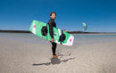 Rider in spiaggia con la sua twintip e il kite Duotone Mono 2026 in volo