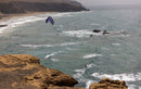 Duotone Neo 2026 en surf dans les vagues le long d'une côte de falaises rocheuses