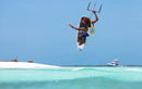 Rider haciendo un aéreo strapless con la Duotone Neo 2027 junto a una playa de arena blanca