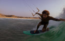 Rider agachado na parede da onda com o kite Duotone Neo 2026, grande plano