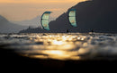 Two Duotone Rebel D/LAB 2026 kites over the river at sunset in a mountain canyon