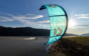 Turquoise Duotone Rebel D/LAB 2026 kite in the foreground as a rider rides the river at sunset