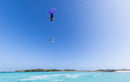 Rider a fazer uma manobra invertida no ar com o kite Duotone Rebel SLS 2027 sobre uma lagoa tropical