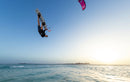 Rider en saut big air avec le kite Duotone Rebel SLS 2027 (version coloris) au-dessus de la mer au coucher du soleil