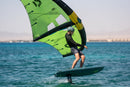 Rider con wing verde volando en foil con la Duotone Skybrid SLS 2027 en aguas turquesas