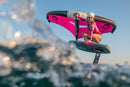 Rider agachada na prancha de foil com a Duotone Unit 2025 rosa entre salpicos