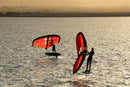 Dos riders con los Duotone Unit 2027 rojos al atardecer en aguas tranquilas