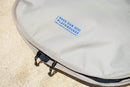 Detalle del logotipo Save Our Playgrounds en la funda Duotone Wing Boardbag Mid-length 2027 marfil
