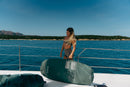 Rider llevando la funda Duotone Wing Boardbag Single 2027 verde por la cubierta de un barco