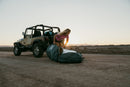 Rider preparando la funda Duotone Wing Boardbag Single 2027 junto a un todoterreno con el sol bajo