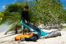 Rider sacando una tabla de wing de la Duotone Wing Team Bag 2027 marfil en la playa