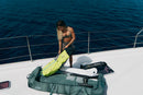 Rider guardando un ala de wing en la Duotone Wing Team Bag 2027 verde en la cubierta de un barco