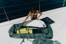 Rider colocando el equipo de wing dentro de la Duotone Wing Team Bag 2027 verde en un barco