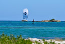 Rider a navegar de foil com o kite North Code Zero Pro 2025 em água turquesa junto a uns ilhéus