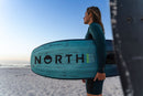 Rider en la playa con la North Echo Pro 2026 bajo el brazo
