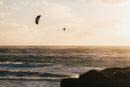 Rider no ar com o North Orbit Ultra 2026 sobre o mar com luz de fim de tarde