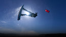 Backlit freestyle rider mid-jump with the North Pulse 2025 kite in Rubine Red