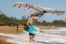 Rider entrando al mar con la North Seek Pro 2026 y la wing en alto