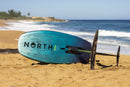 North Seek Pro 2026 con el foil montado, tumbada en la arena de la playa